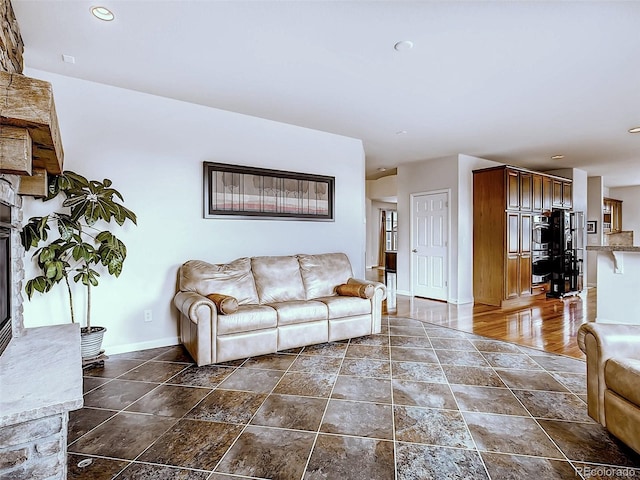 living room with a stone fireplace and dark hardwood / wood-style floors