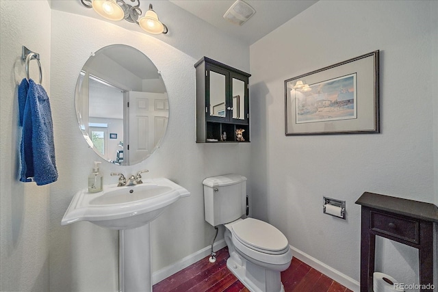 bathroom featuring wood-type flooring and toilet