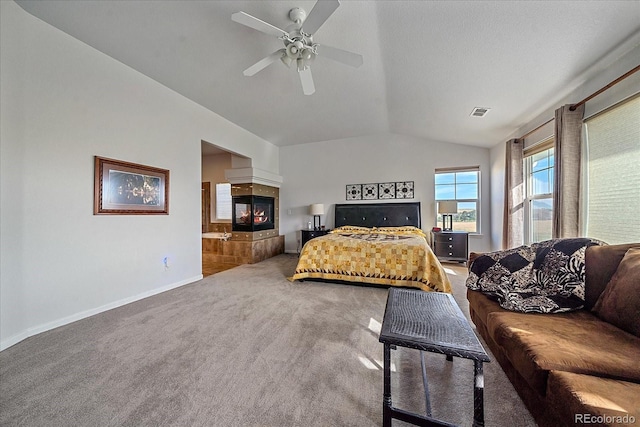 bedroom with carpet flooring, a multi sided fireplace, vaulted ceiling, and ceiling fan