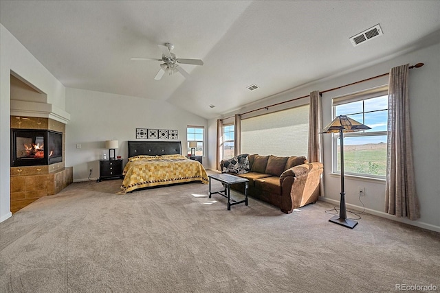 carpeted bedroom featuring a multi sided fireplace, vaulted ceiling, and ceiling fan