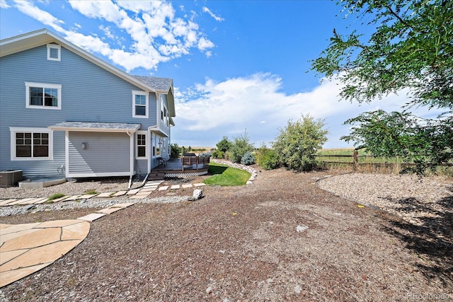 rear view of property featuring a deck and central AC