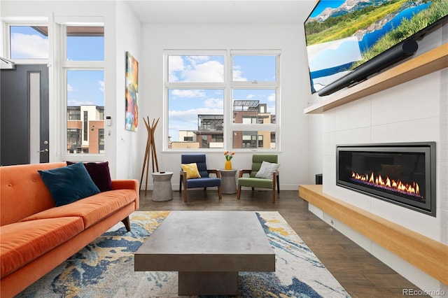 living room featuring a tile fireplace and dark hardwood / wood-style floors