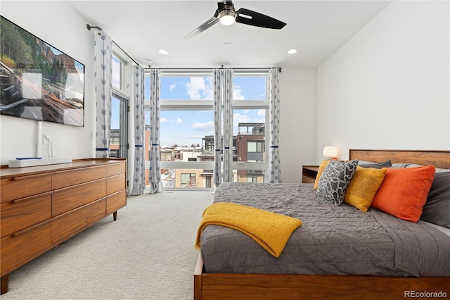 carpeted bedroom featuring ceiling fan, expansive windows, and access to outside