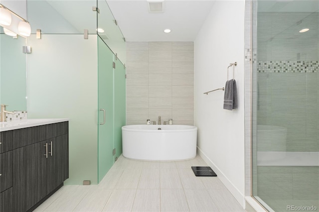 bathroom featuring tile walls, tile patterned floors, vanity, and plus walk in shower