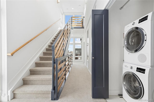 laundry area featuring light carpet and stacked washer and dryer