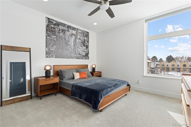 bedroom with multiple windows, light colored carpet, and ceiling fan