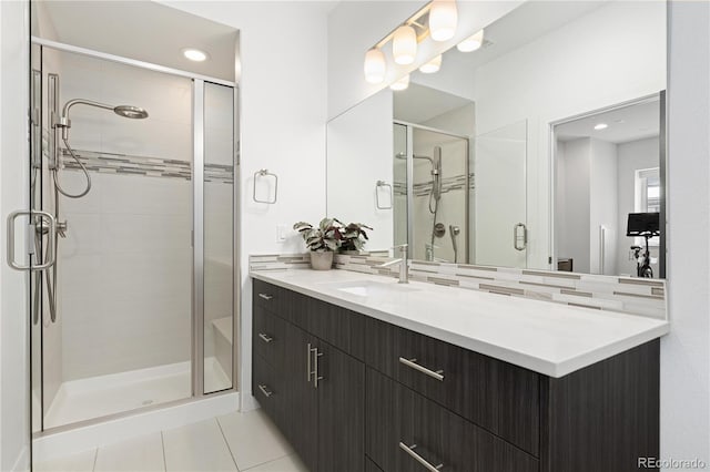 bathroom with backsplash, tile patterned flooring, walk in shower, and vanity