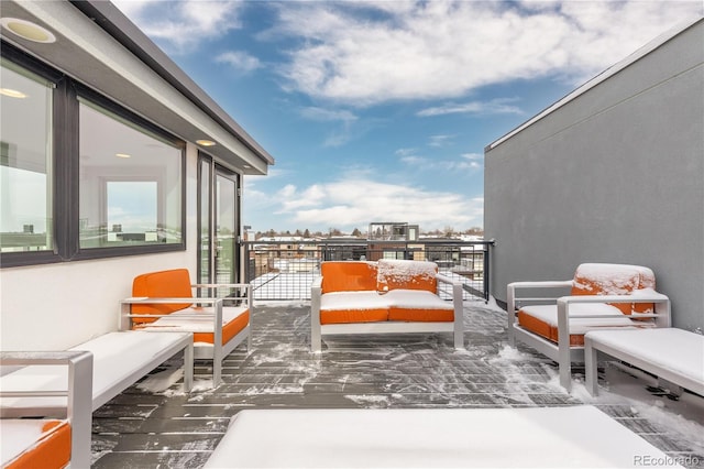 snow covered back of property featuring an outdoor living space