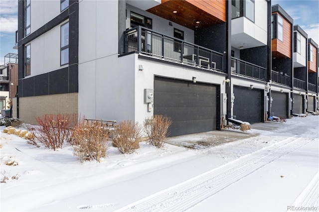 snow covered building featuring a garage