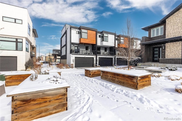 snowy yard featuring a garage