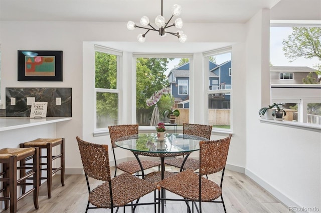 dining space featuring light wood-style flooring, plenty of natural light, and a chandelier
