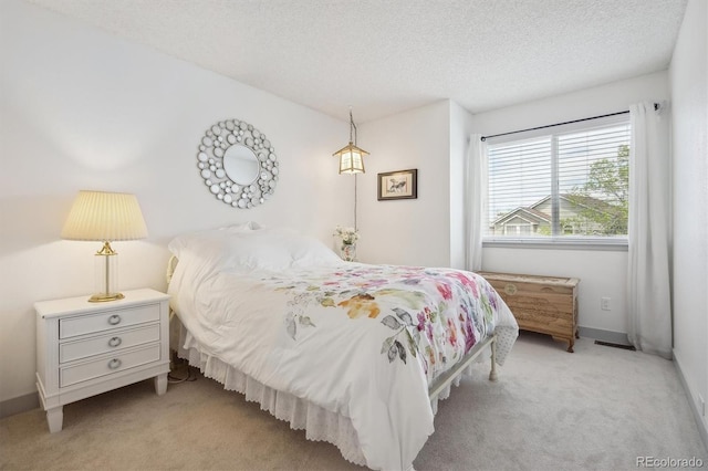 bedroom featuring carpet flooring, a textured ceiling, and baseboards