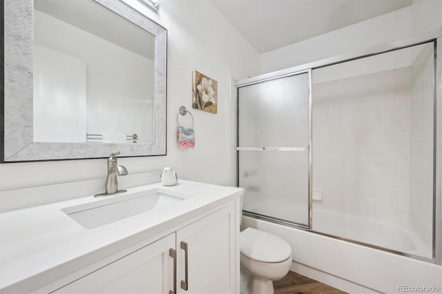 full bathroom featuring toilet, vanity, shower / bath combination with glass door, and wood finished floors