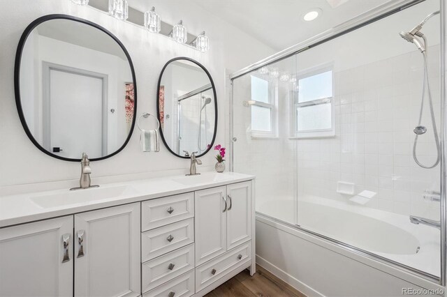 bathroom featuring double vanity, combined bath / shower with glass door, and wood finished floors