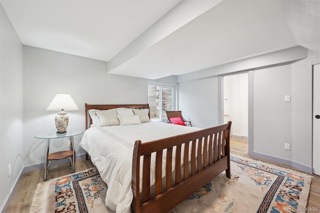bedroom with wood finished floors and baseboards