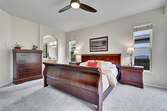 10653 W Parkhill Dr, Littleton, CO 80127 - carpeted bedroom featuring arched walkways, baseboards, ensuite bathroom, and a ceiling fan
