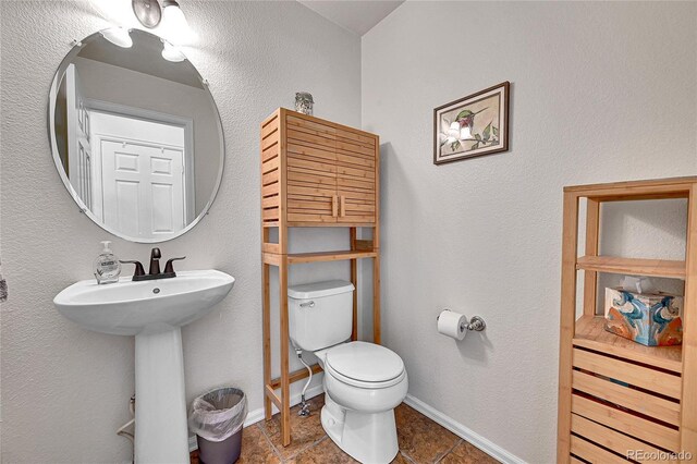 10653 W Parkhill Dr, Littleton, CO 80127 - half bathroom with toilet, baseboards, tile patterned floors, and a sink