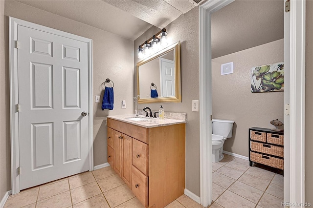 10653 W Parkhill Dr, Littleton, CO 80127 - bathroom featuring tile patterned floors, vanity, toilet, a textured wall, and baseboards