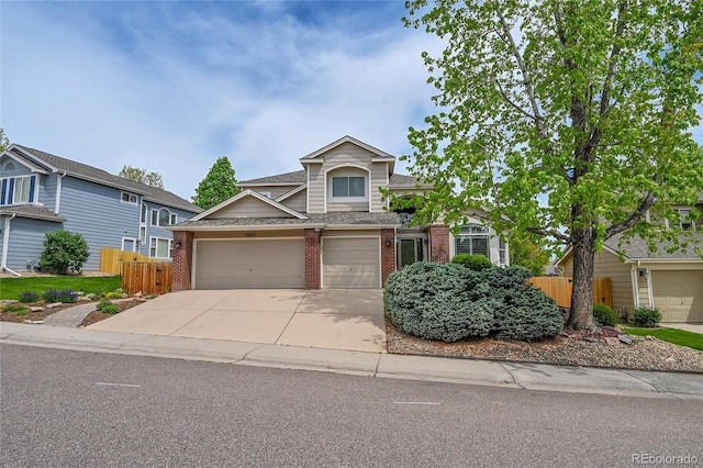 10653 W Parkhill Dr, Littleton, CO 80127 - traditional home featuring brick siding, fence, driveway, a shingled roof, and a garage