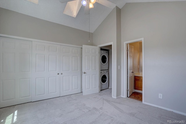 unfurnished bedroom with stacked washer / dryer, baseboards, carpet floors, a closet, and ensuite bathroom