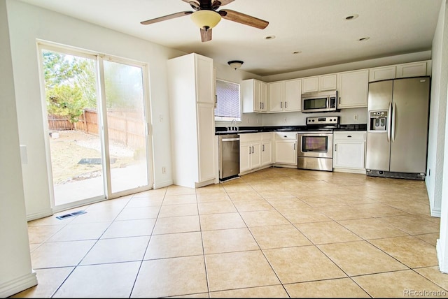 kitchen featuring appliances with stainless steel finishes, white cabinetry, light tile patterned floors, and ceiling fan