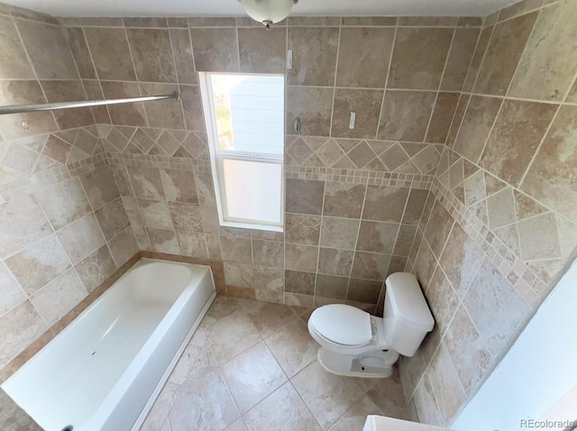 bathroom with tile patterned flooring, tile walls, and toilet