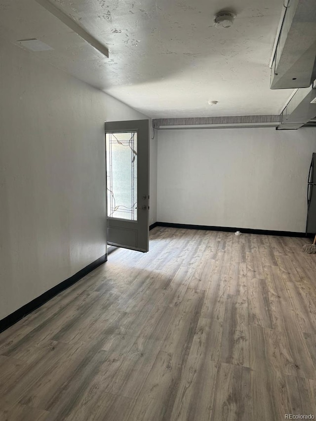 unfurnished room featuring hardwood / wood-style floors and a textured ceiling