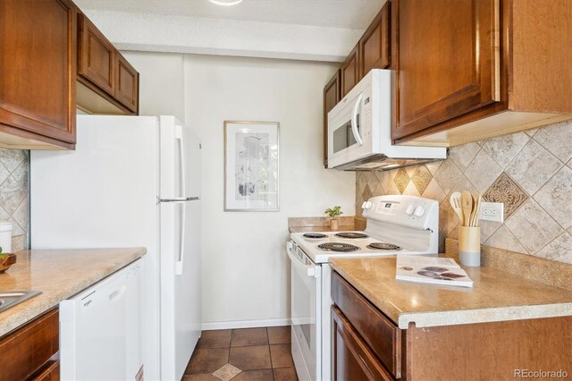 4801 E 9th Ave Unit 402S, Denver, CO 80220 - kitchen featuring white appliances, decorative backsplash, brown cabinetry, and light countertops
