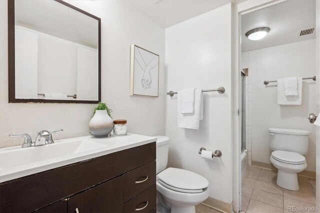 4801 E 9th Ave Unit 402S, Denver, CO 80220 - full bath featuring toilet, vanity, tile patterned floors, bath / shower combo with glass door, and baseboards