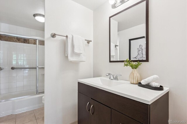4801 E 9th Ave Unit 402S, Denver, CO 80220 - bathroom featuring vanity, shower / bath combination with glass door, tile patterned flooring, and toilet