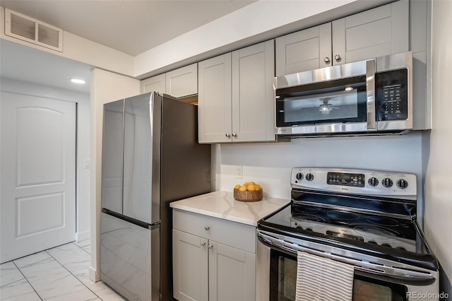 kitchen with light stone countertops and stainless steel appliances