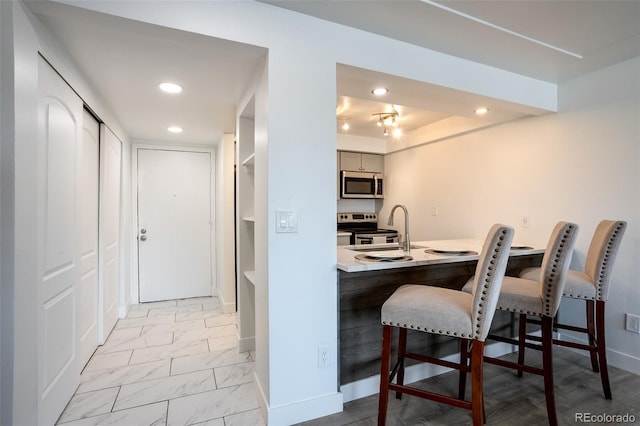 kitchen featuring appliances with stainless steel finishes, sink, and a breakfast bar area