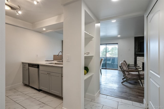 kitchen with sink, gray cabinetry, and stainless steel dishwasher