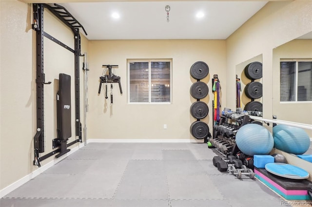 exercise area featuring baseboards, recessed lighting, and a barn door