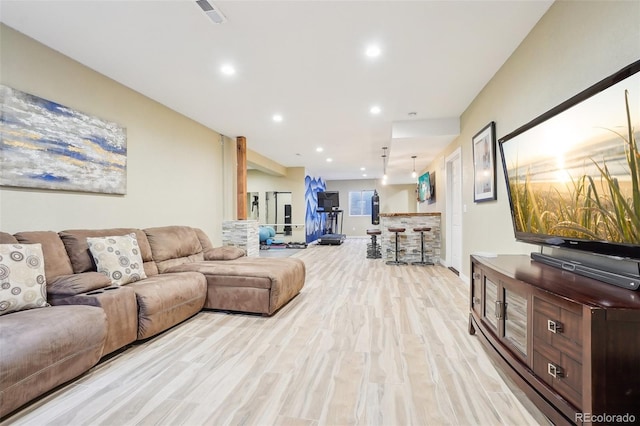 living area with recessed lighting, visible vents, and light wood-type flooring