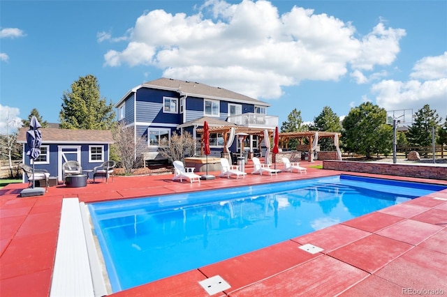 pool featuring a pergola, an outdoor structure, and a patio area