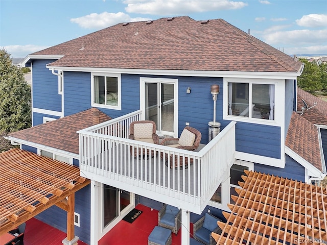 rear view of property with roof with shingles