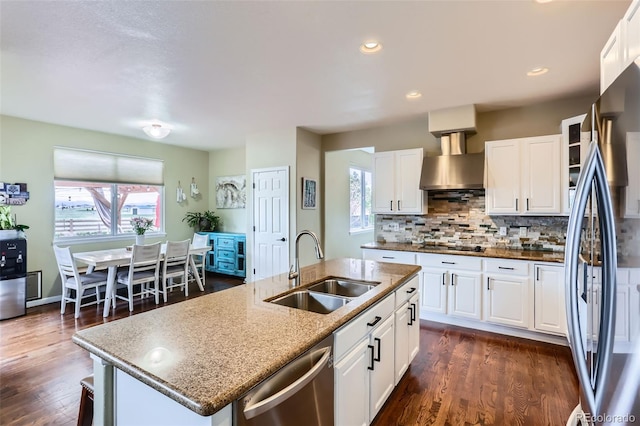 kitchen featuring a sink, appliances with stainless steel finishes, plenty of natural light, and wall chimney range hood