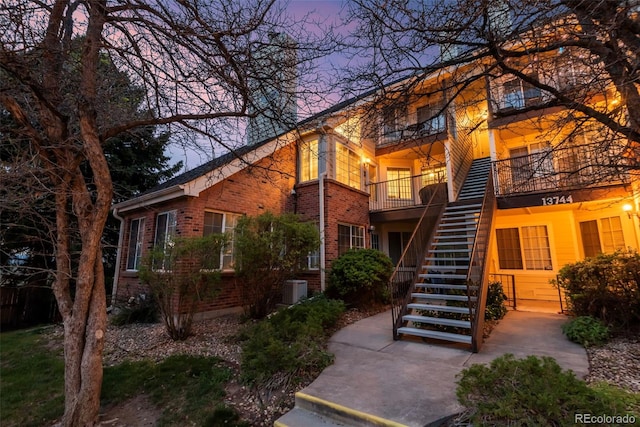 13744 E Lehigh Ave Unit B, Aurora, CO 80014 - view of front of home featuring stairway, a balcony, brick siding, and central AC