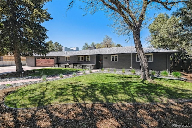 ranch-style house with a chimney, an attached garage, a front lawn, and driveway