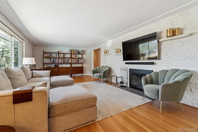 living area with wood finished floors and a brick fireplace