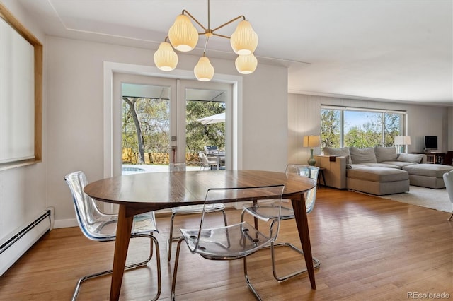 dining room featuring a baseboard heating unit, wood finished floors, and french doors