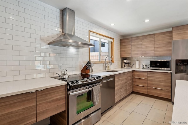 kitchen with appliances with stainless steel finishes, range hood, a sink, backsplash, and brown cabinetry