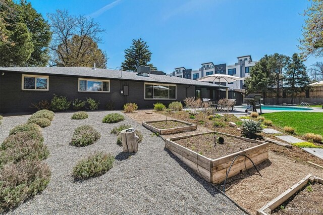 back of property featuring a garden and fence