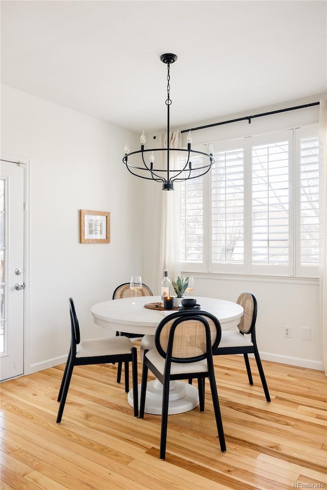 dining space with an inviting chandelier and light hardwood / wood-style flooring