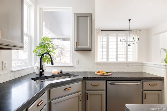 kitchen featuring decorative light fixtures, sink, gray cabinetry, a chandelier, and stainless steel dishwasher