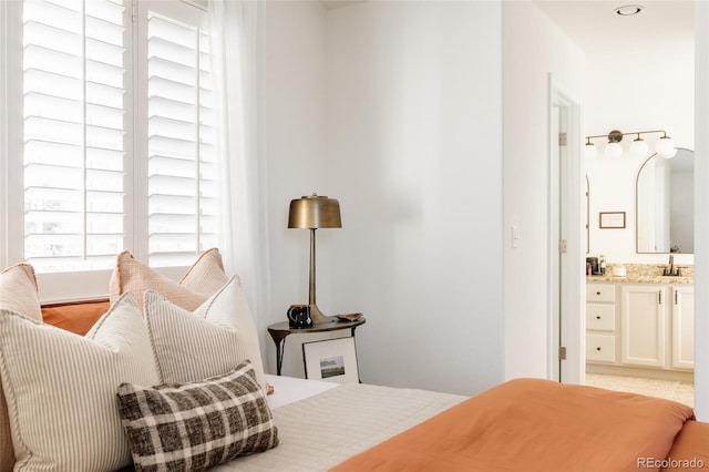 bedroom with sink and connected bathroom