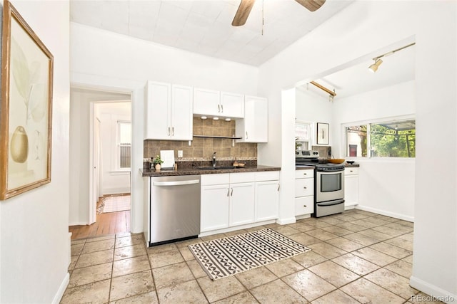 3147 W 39th Ave, Denver, CO 80211 - kitchen featuring appliances with stainless steel finishes, decorative backsplash, a sink, white cabinets, and dark countertops
