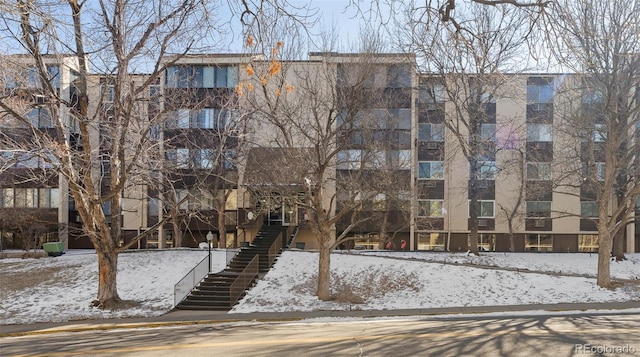 snow covered property featuring stairs