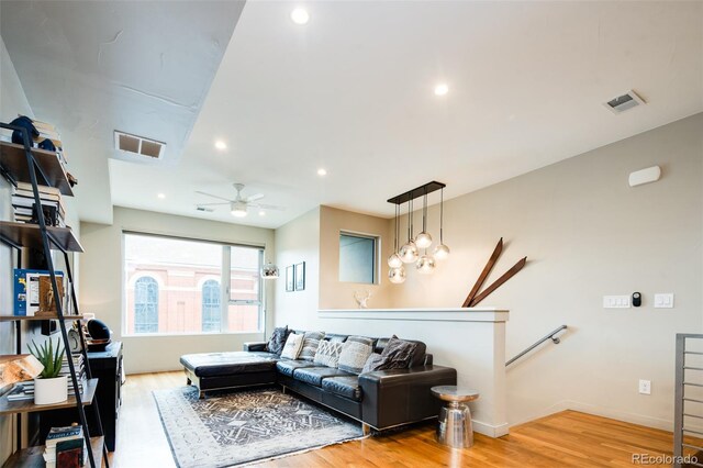 living room featuring ceiling fan and light hardwood / wood-style flooring